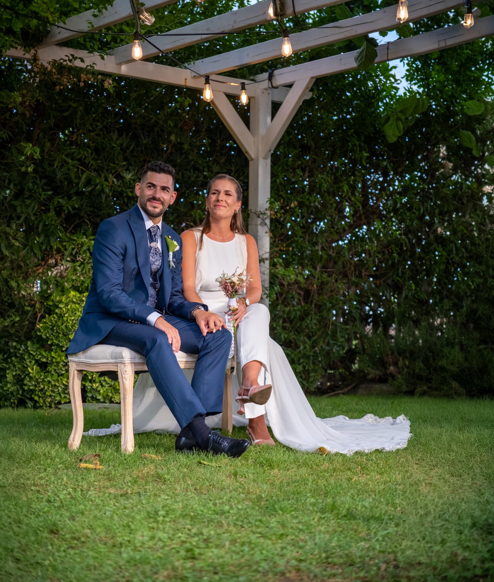 Novios abrazados en un jardín al atardecer